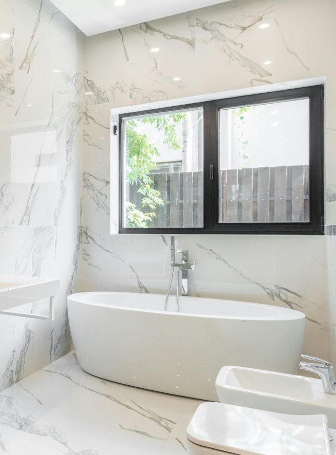 Swansea bathroom with walls and floors fully tiled in white marble.